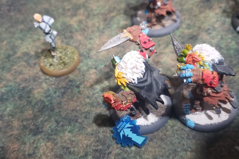 Rear view of a Trollblood Northkin Raider survives being knocked down from a Crucible Guard Trancer's slam.